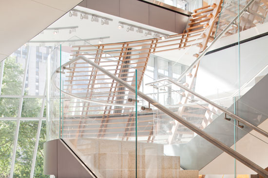 Recessed glass handrail shoes hidden by painted aluminum fascias and custom stainless steel railings and stand-offs maintain the stair’s weightless appearance in the atrium at the Rockefeller University Building.