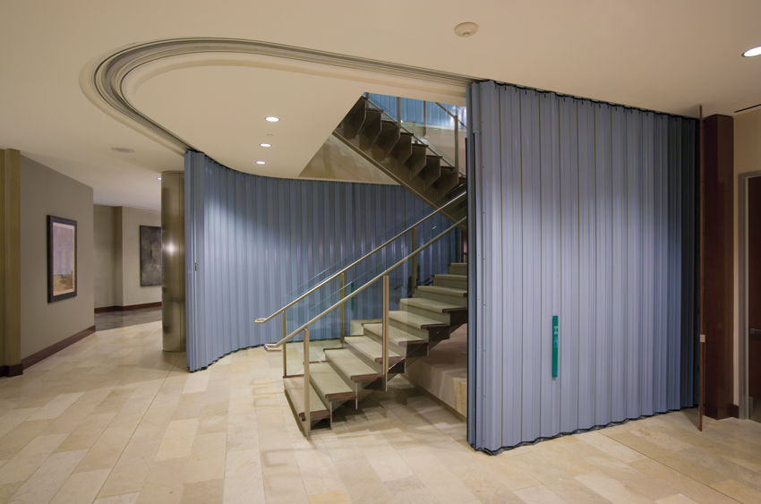 Photo of curved sliding fire doors around multistory stairways.