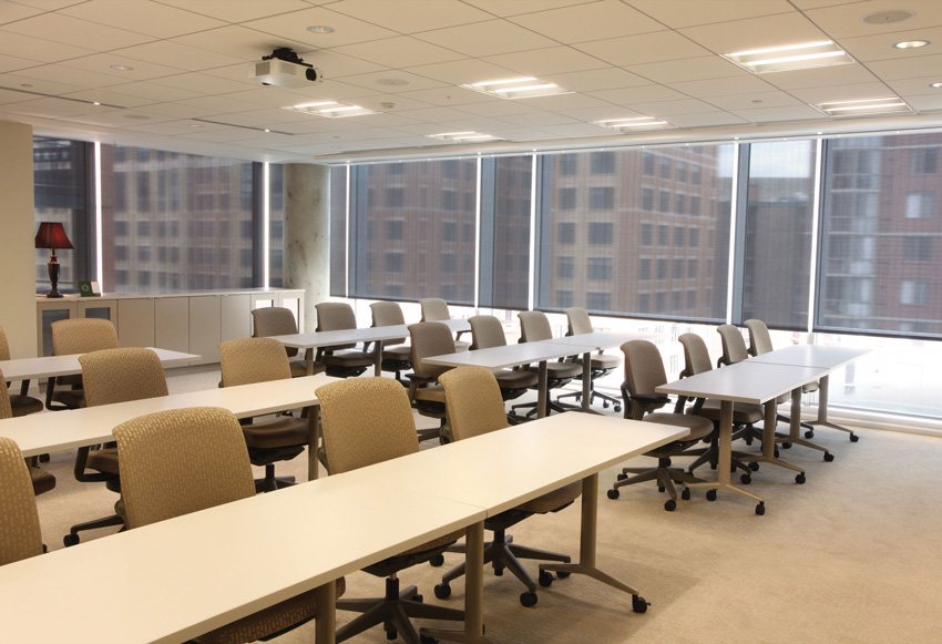 Photo of a lecture room interior with solar shade fabric on the windows.