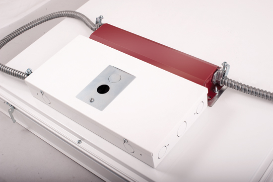 A driver for an LED fixture is a small thin unit that can be mounted to an LED light fixture. The red portion shown next to the driver is a back-up battery option for emergency lighting.