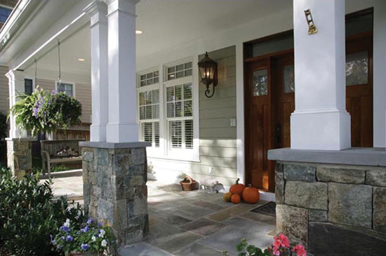 The plain non-tapered 8 inch by 6 foot shafts with chamfered base and decorative capital used outdoors on this porch are inspired by architecture of the Arts and Crafts period in America