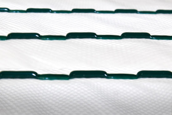Continuous spacers provide an intended drainage gap on a synthetic, non-woven, breathable WRB.