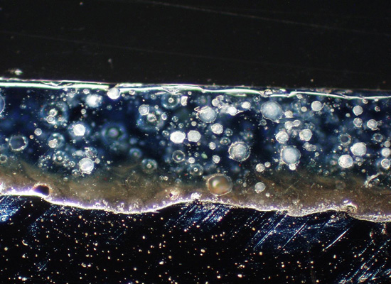 100x magnification showing a two-coat-one fire (2c1f) process without titanium dioxide that results in larger bubble structure, thus allowing a direct path for corrosion.