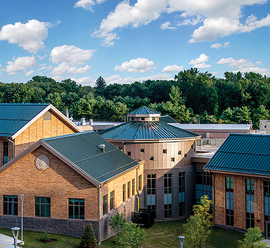 The versatility of metal roofing panels is displayed in Perkins Eastman’s design on the International Magnet School which features a circular, segmented Snap-Clad metal panel roof surrounded by connecting rectangular pitched structures.