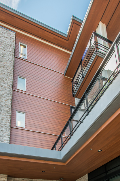 The manufacturing process for wood-grained aluminum siding allows for a range of color schemes that can complement other materials. Project: Sotaire (multifamily residential)