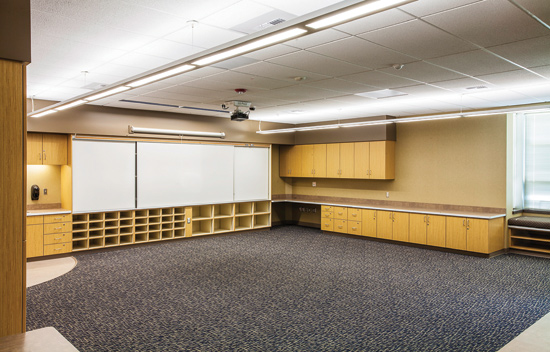 Recessed wall wash fixtures illuminate the white boards while indirect/direct luminaires provide general illumination at Sunset View Elementary School in Kennewick, Washington, designed by MMED Architecture. 