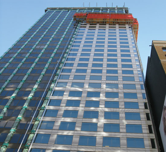Movable scaffolding on the outside of a building is often the most efficient and least disruptive method to provide replacement or over-clad curtain wall systems on existing buildings.