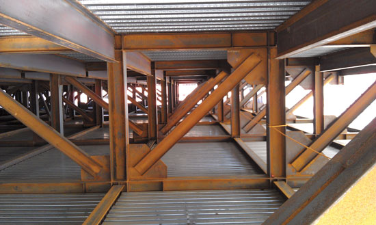 At the State University of New York Institute of Human Performance Upstate Medical University, structural steel was selected for this laboratory expansion project. Pictured above, upper floor and mechanical penthouse levels of the steel frame with horizontal bracing members at the roof and attachments will support a tied-back infill skylight. In the photo to the right, the full-story transfer girders serving as an interstitial-level MEP services distribution zone can be seen. 