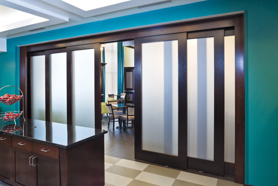 Telescoping door systems smoothly retract and extend multiple door panels moving in the same direction, providing an elegant barrier solution for large openings. 