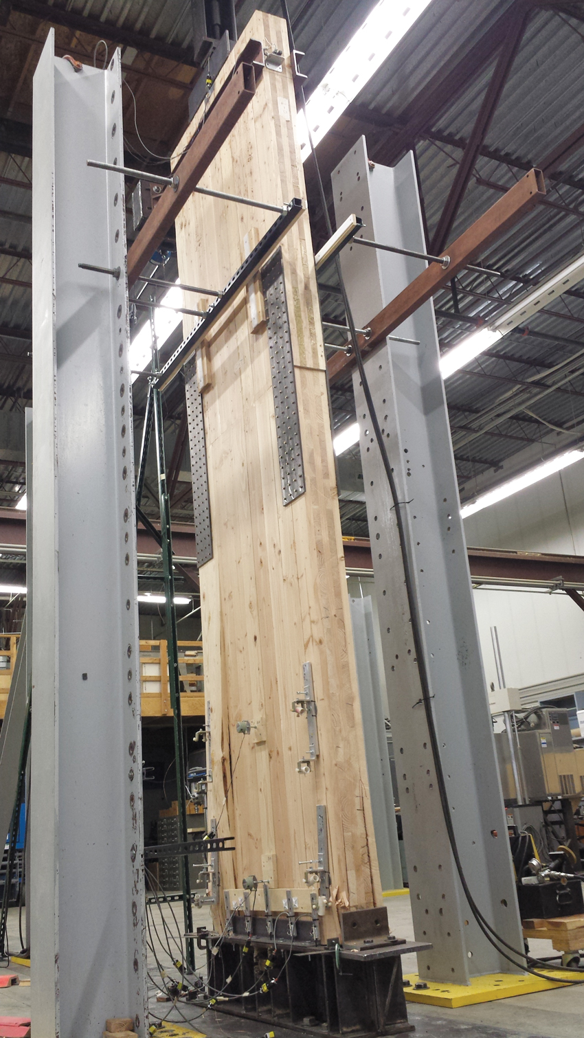 In this rocking test of a CLT shear wall, the panel maintained its lateral load-bearing strength under cycling loading to simulate seismic conditions and returned to a vertical position at completion of the test. 