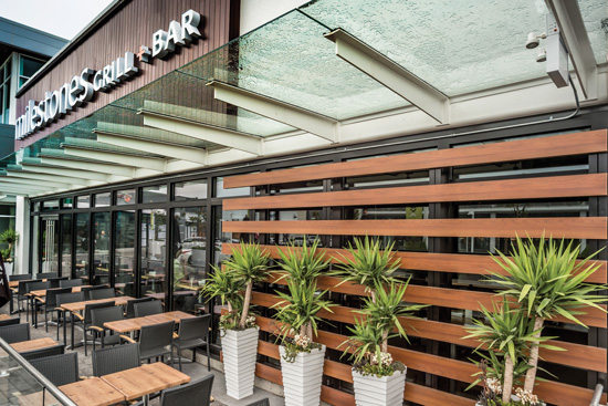  Woodgrain aluminum tubes in a light cherry finish are used for a privacy screen at a terrace restaurant. 