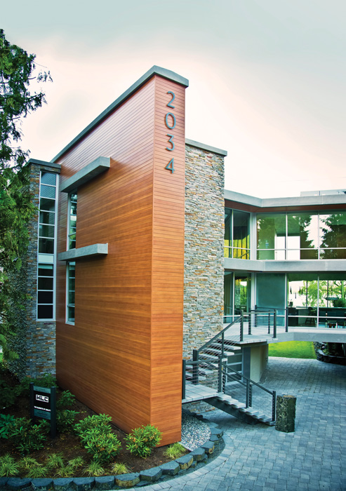  Steven Morris Cross Architect combined wood-patterned aluminum panels with glass spans, stone cladding, and 1,500 square feet of aluminum siding and soffit panels in a light cherry finish 
