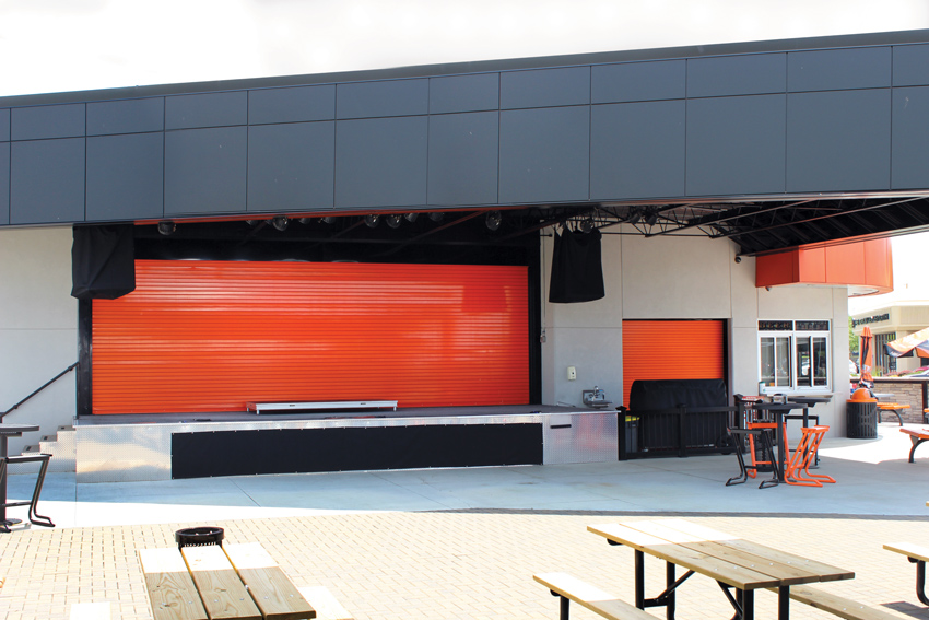 New durable rolling doors are meeting and exceeding energy codes, providing improved sound attenuation, and can be finished with attractive, no-VOC colors, as shown in the door for this new Harley Davidson distributor facility. The rolling steel doors protect the venue and equipment when not in use. The doors were powder coated with an orange that matches the brand’s color guidelines.
