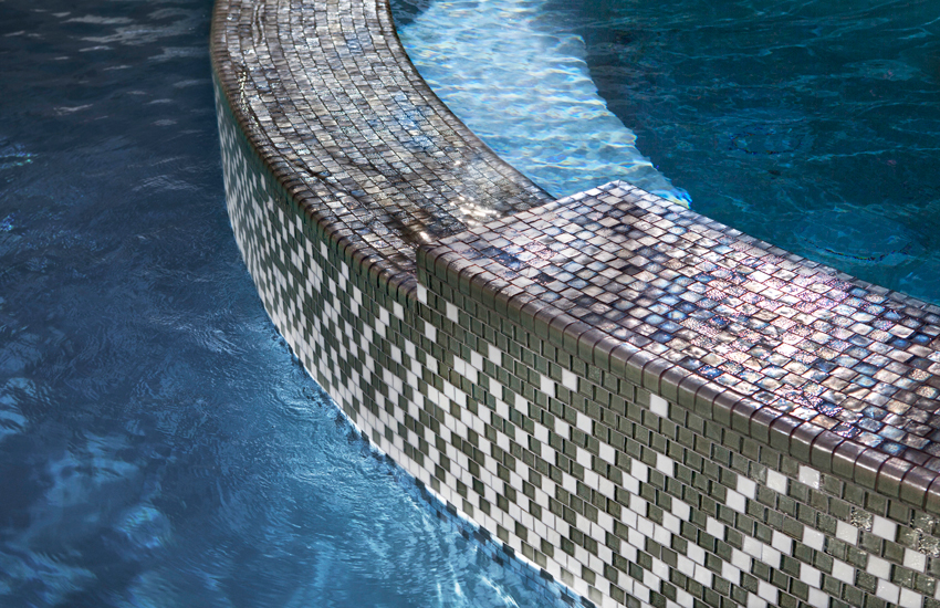 Key considerations for glass tiles in pools, spas, and natatoriums include tile size and dimensional ratios because long rectangular shapes can be less stable at the center of the tile and may be more prone to fracturing. 
