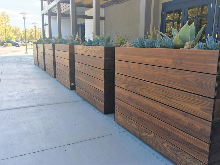 Thermally modified wood planters enhance an urban streetscape.