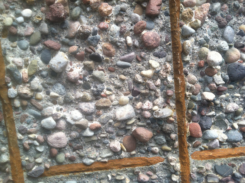 Photo of rusted steel embedded in concrete.