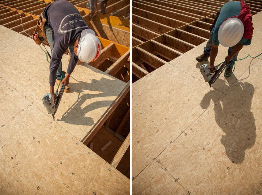 Photo of workers applying screws in preprinted marks on subfloor panels.