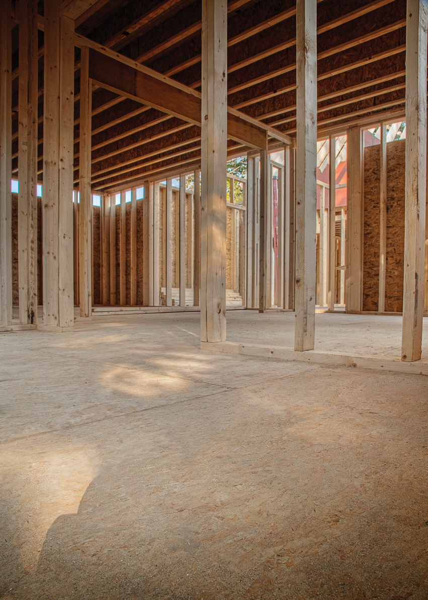 Photo of an interior with wood floors under construction.