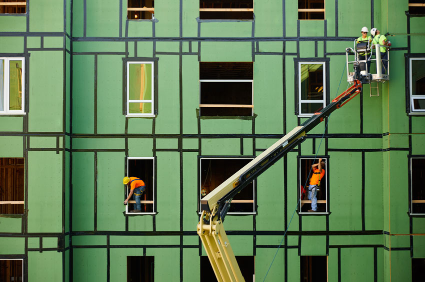 Green building with construction workers for building enclosures