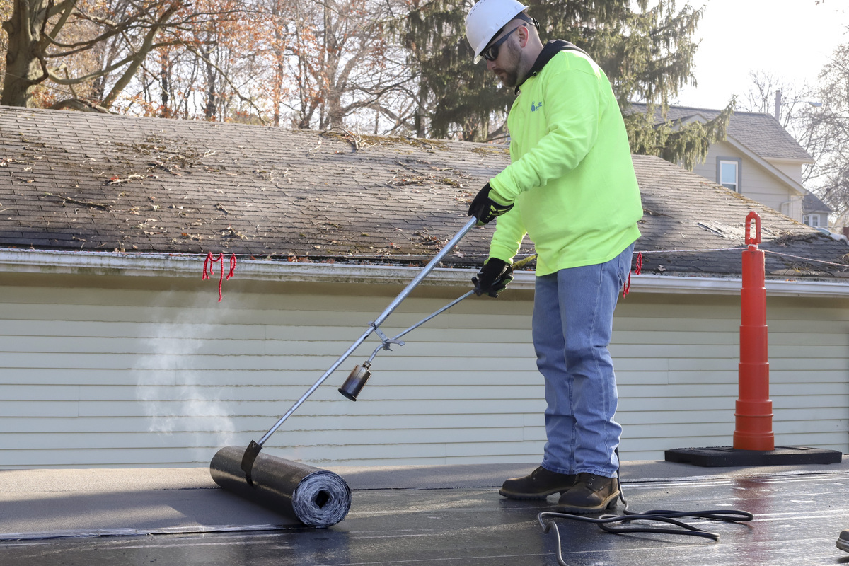 Photo of workers applying roof ply.