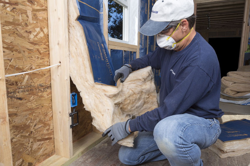 Photo of a worker installing insulation.