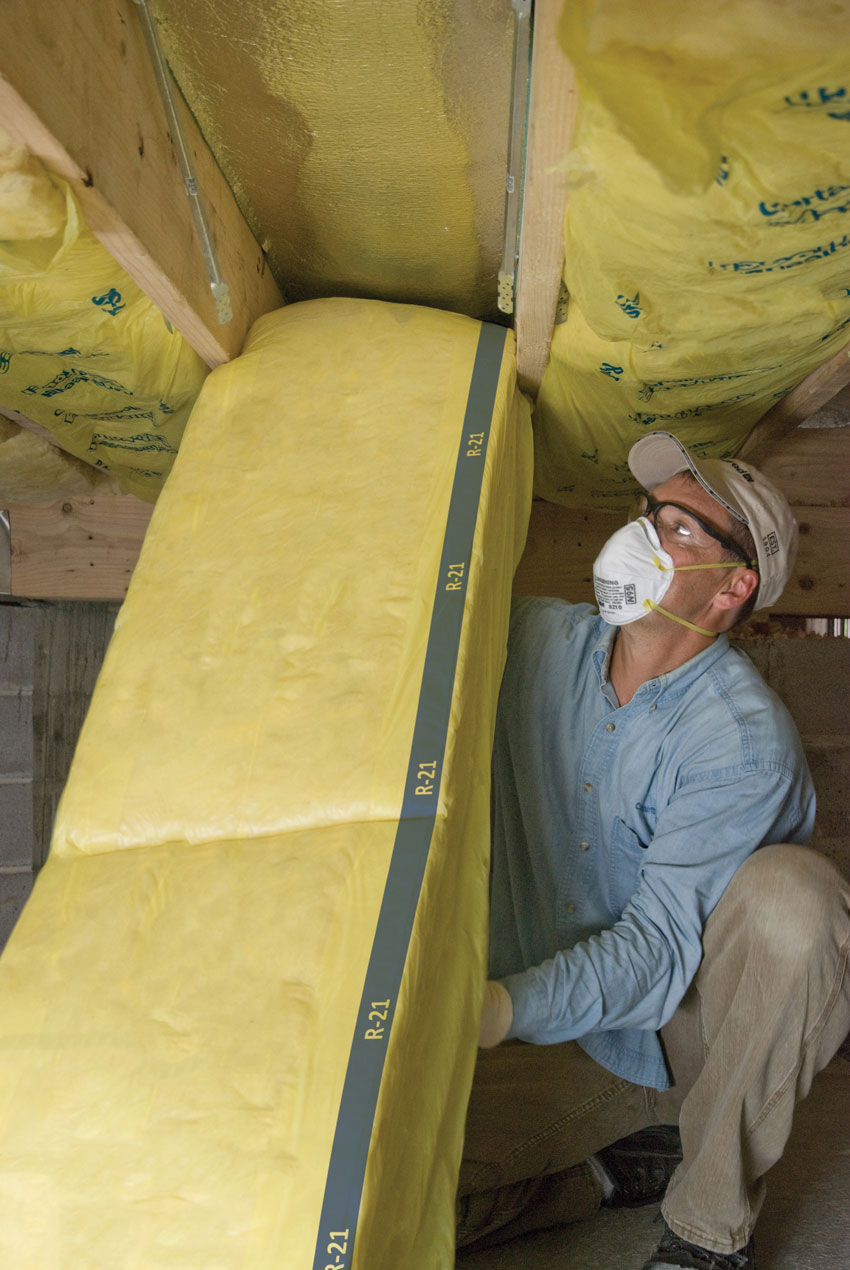 Photo of a worker installing insulation.
