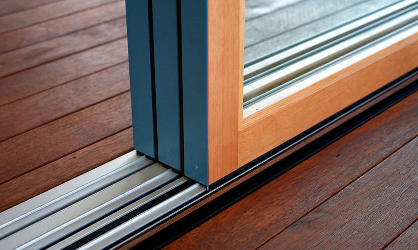 Stacking multi-slide panels stack flush when fully opened. Aluminum wood multi-slide system shown with flush sill. 