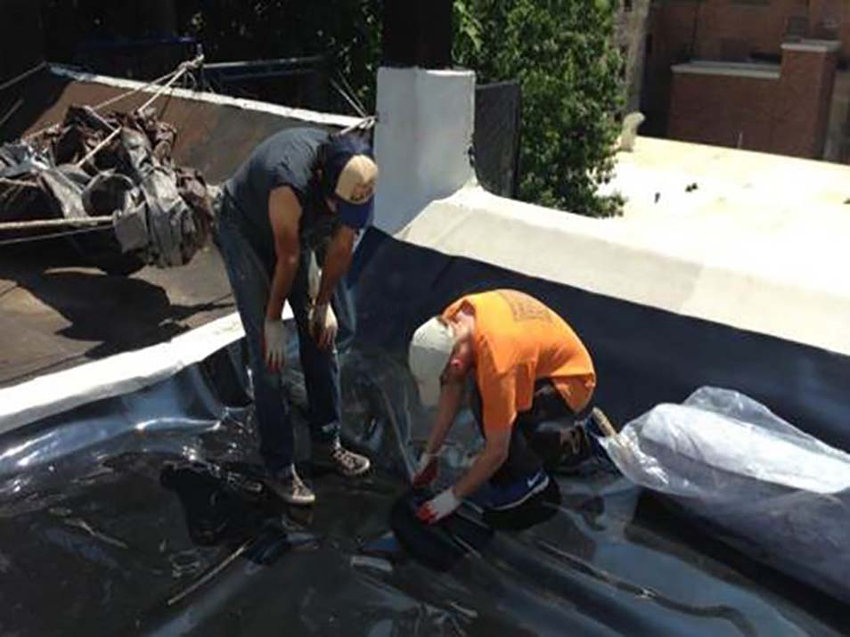 Two men install a polyethylene root barrier