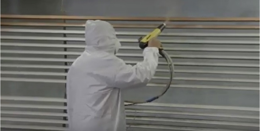 Man spraying liquid paint on an extruded Aluminum trim