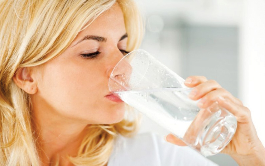 blonde lady drinking a glass of water